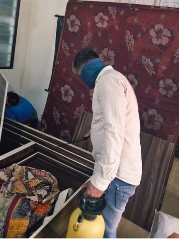 Tezz technician spraying a wooden bed frame with the mattress lifted during a bed bug treatment