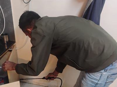 Technician applying treatment along a counter and cabinet junction