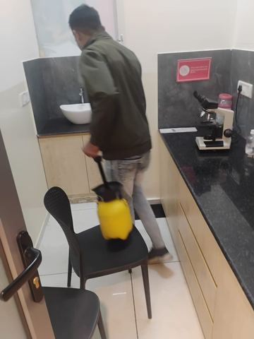 Technician treating a laboratory bench and cabinet line